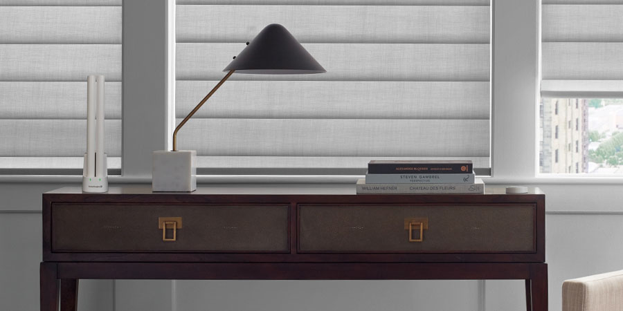 PowerView® rechargeable battery wands charging beside Hunter Douglas Pirouette® Shades