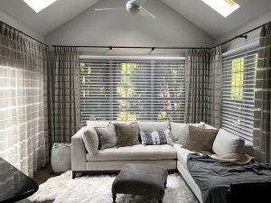 angled ceiling living room with large windows covered with silhouette shades and plaid draperies in Rocky River OH