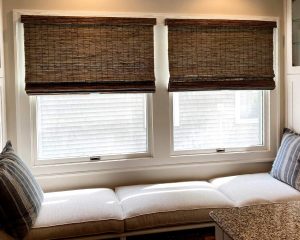 woven roman shades next to window seat