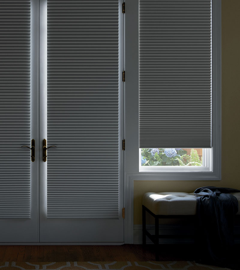 room darkening cellular shades over glass front door and adjacent window