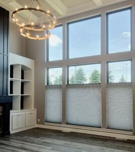 large windows covered by gray honeycomb shades for energy efficiency