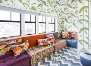 colorful interiors fill this home playroom with wallpaper and couch cushions