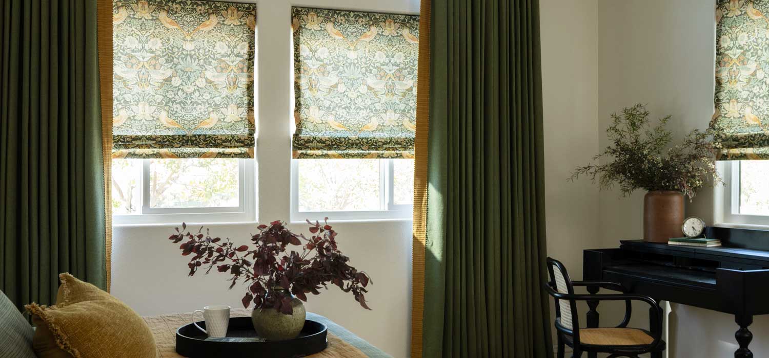 roman shades in bedroom paired with custom drapery