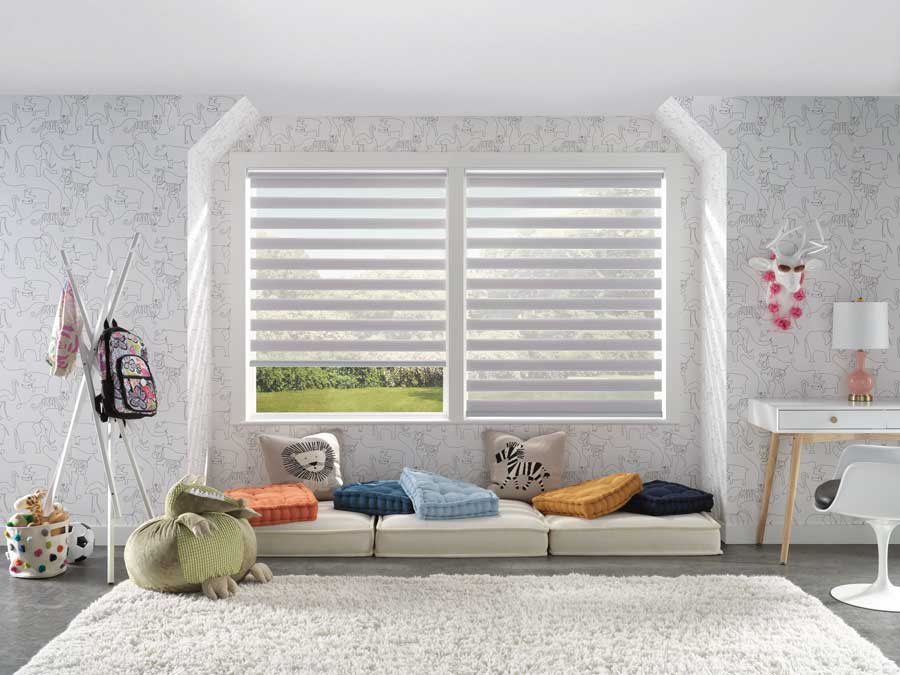 large window with white window shades with colored pillows and cushions infront of them