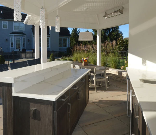 outdoor cabinets with outdoor kitchen with white counter top and brown cabinets