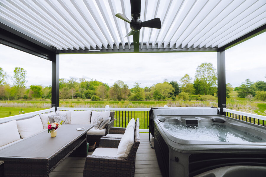 outdoor pergola with fan over hot tub and dining area
