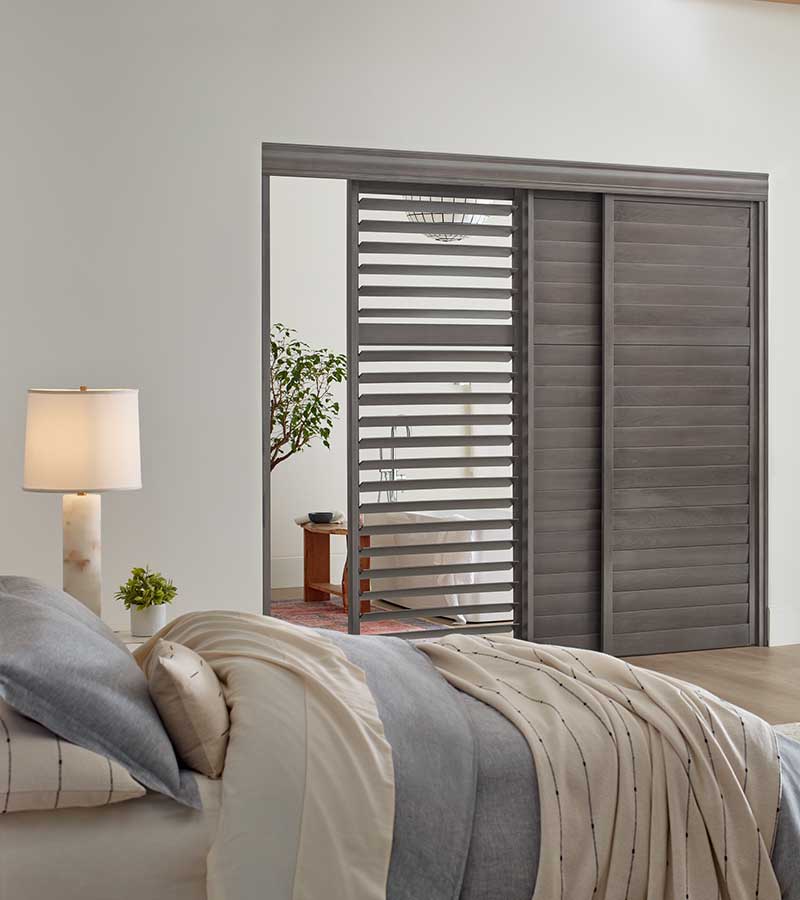 gray sliding heritance shutters as room divider in bedroom