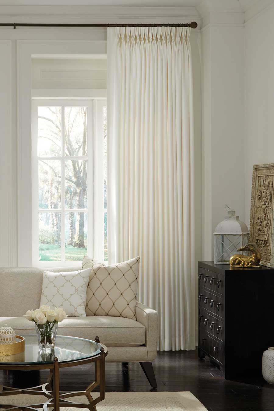 off-white triple pinch pleat drapery in a living room in Cleveland with a black drapery rod