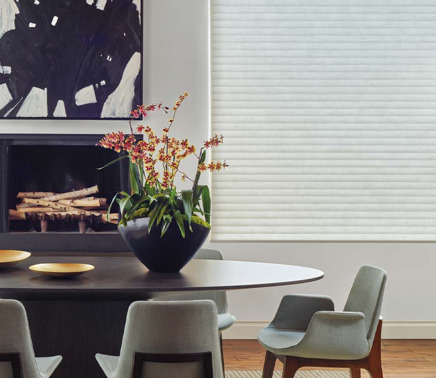 sonnette-cellular-roller-shades-dining-room-wide-window-light-filtering-gray-timan-and-co Hunter Douglas Sonnette® Cellular Roller Shades covering a wide dining room window with light-filtering fabric